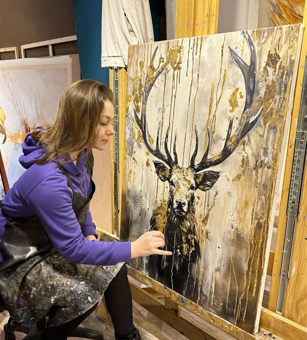 Kübra at work in her atelier on a gold-leaf stag painting